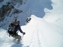 A skier is rewarded for their climb with an exciting descent.
