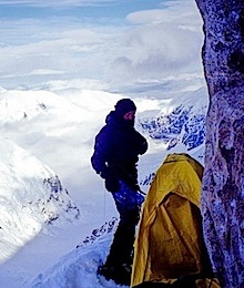 A climber settling into a bivy site high on the Cassin Ridge.