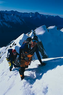 Guide and climber greet the dawn above Mt. Cook's Grand Plateau.