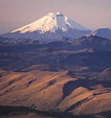 Sunrise on Cotopaxi from Cayambe. Our route follows the S-shaped sunlit snow ridge below and right of the summit.