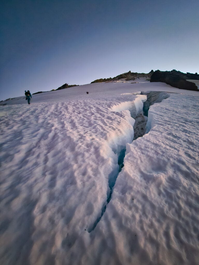 A climber walks near a crevasse