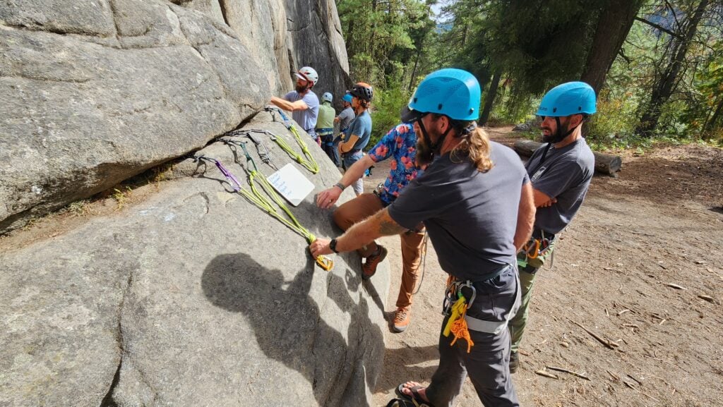 A line of students learning the principles of multi-pitch trad anchor building in Leavenworth, WA