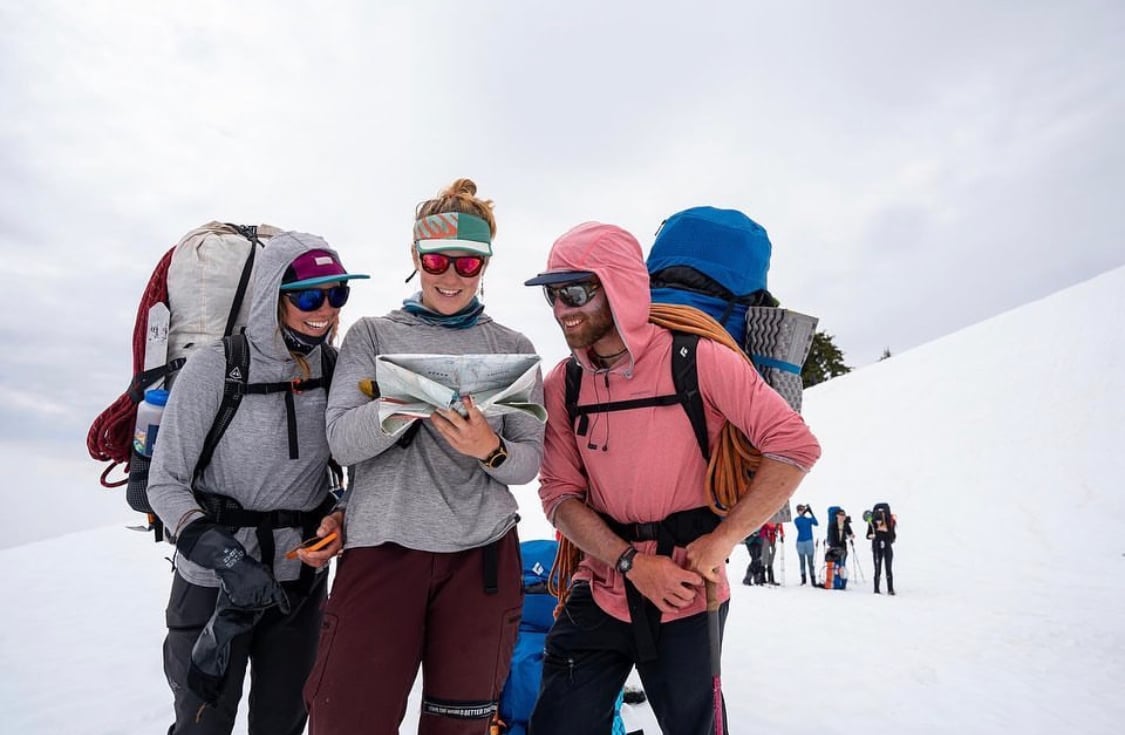 Mountaineering Students look at a map and decipher a plan of navigation