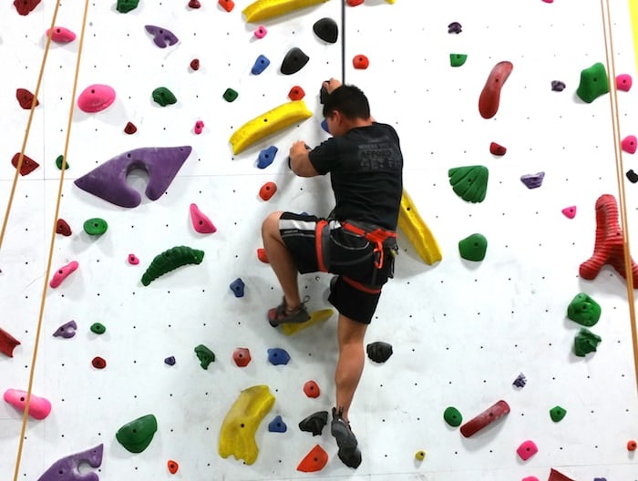 Climber Top-Rope Climbing in Indoor Gym