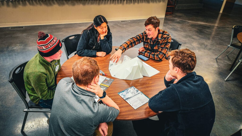 American Alpine Institute AIARE Avalanche 1 students sit around a table learning about avalanche hazards at the Mountain Center