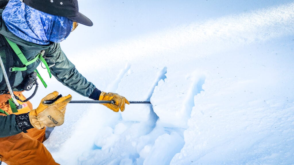 An AIARE student cuts into snow with their ski pole