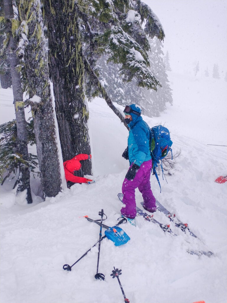 Backcountry tourers simulate being stuck in a tree well.