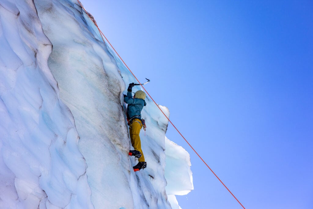 A climber on a top-rope practices their ice climbing skills in the seracs of the Coleman Glacier on Mt. Baker