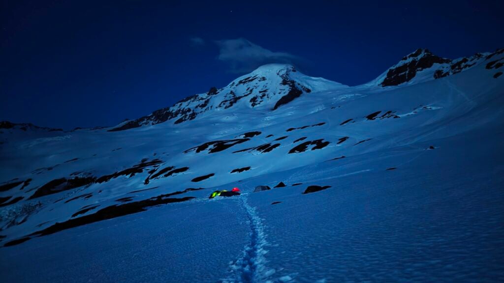 Tents glow at night on the flanks of Mt. Baker