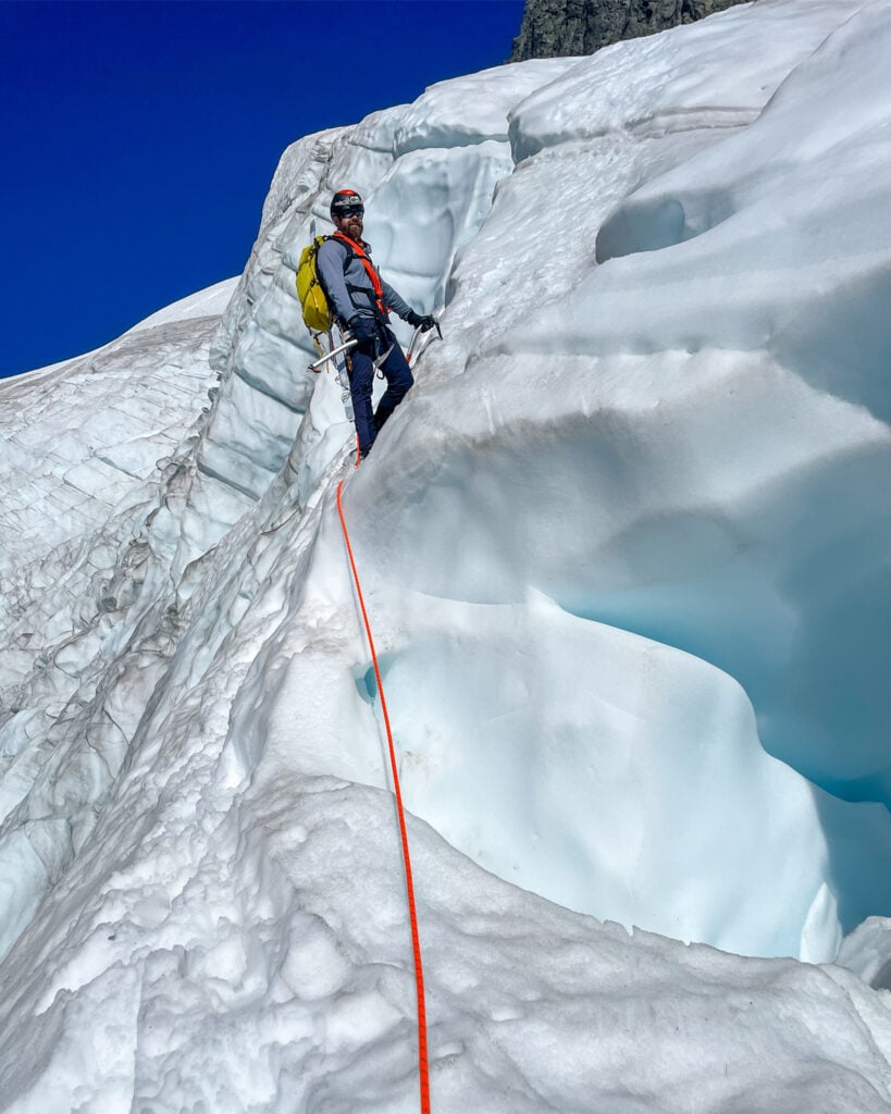 A student climber leading a pitch of broken glacier ice on the Upper Curtis Glacier of Mt. Shuksan