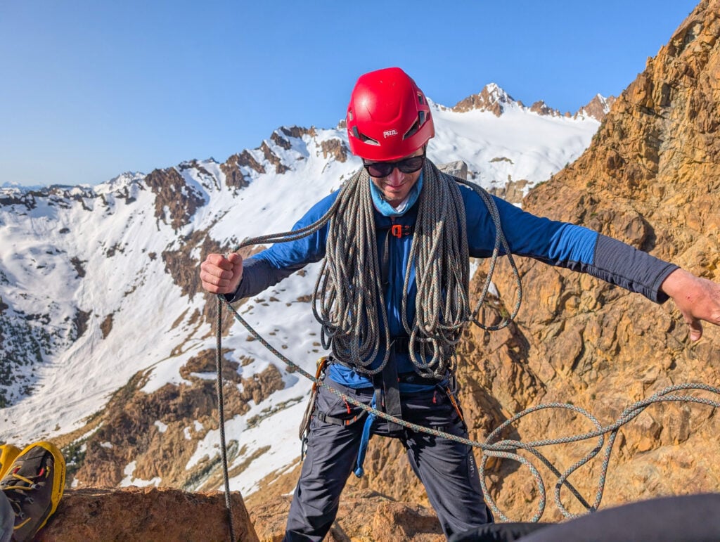 A climber coils the rope, getting ready to store it after topping out of a climb. Ready for the next challenge.