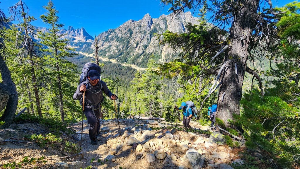 Hikers approach camp with the scenic WA Pass valley below