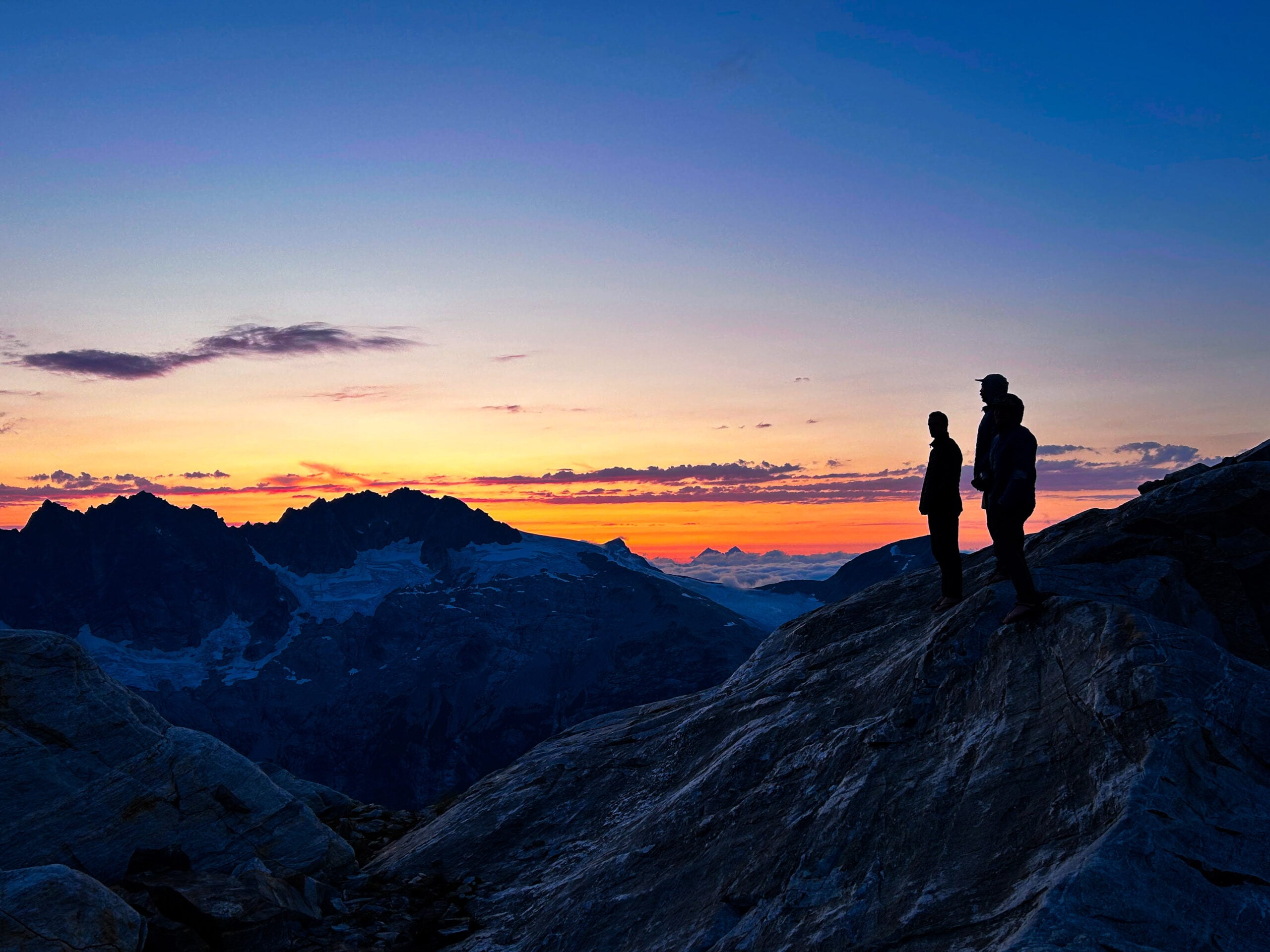 Students watch the sunset from camp in the remote alpine wilderness of the North Cascades during American Alpine Institute Alpine Mountaineering and Technical Leadership Part 4 (AMTL4)
