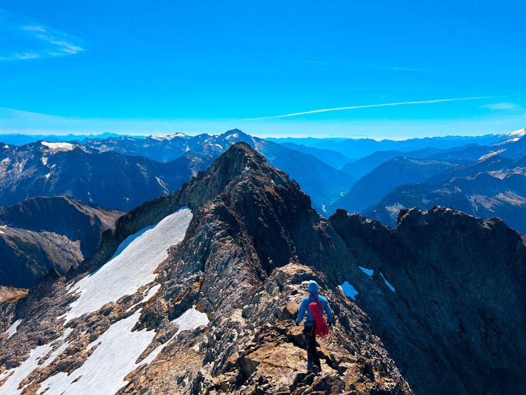 A rock climber traverses a ridge to the summit in the remote alpine wilderness of the North Cascades during American Alpine Institute Alpine Mountaineering and Technical Leadership Part 4 (AMTL4)
