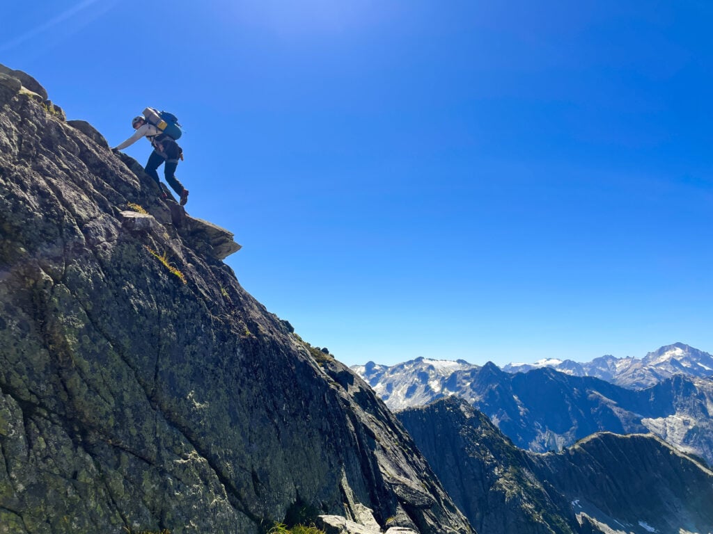 A rock climber ascends a rocky summit in the remote alpine wilderness of the North Cascades during American Alpine Institute Alpine Mountaineering and Technical Leadership Part 4 (AMTL4)