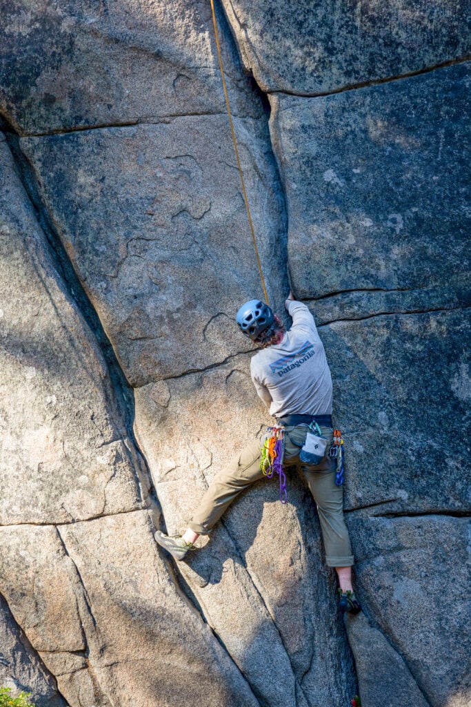 A climber works on their crack technique while on an American Alpine Institute rock climbing course