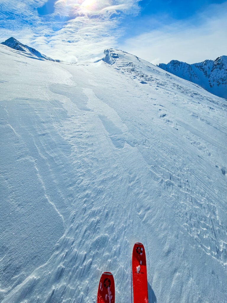 A skier makes their way up a slope in the backcountry of the North Cascades while ski mountaineering on an American Alpine Institute ski course
