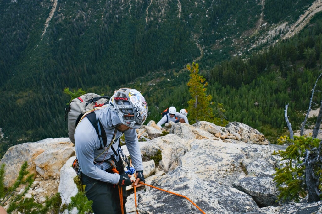 A climber belays his fellow students up a multi-pitch rock climb during the American Alpine Institute's Alpine Mountaineering and Technical Leadership Part 3 program in the North Cascades of Washington