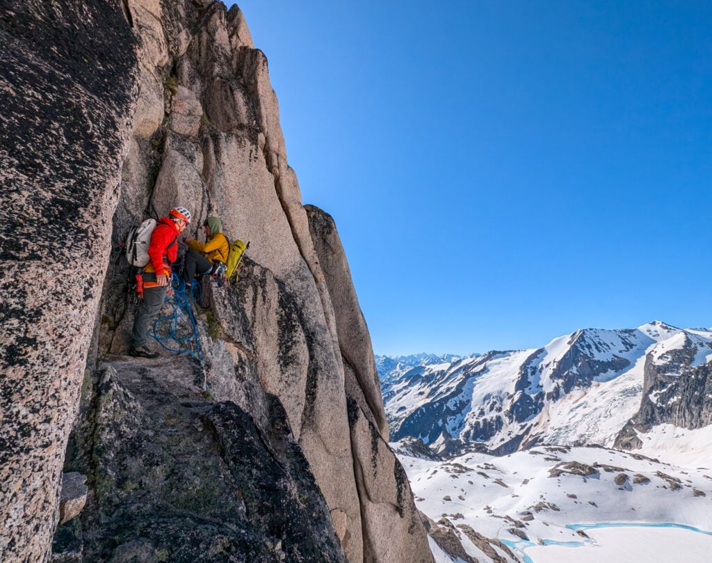 Two climbing students on American Alpine Institute's Alpine Mountaineering and Technical Leadership 3 course at a belay station on a mult-pitch alpine climb in the PNW