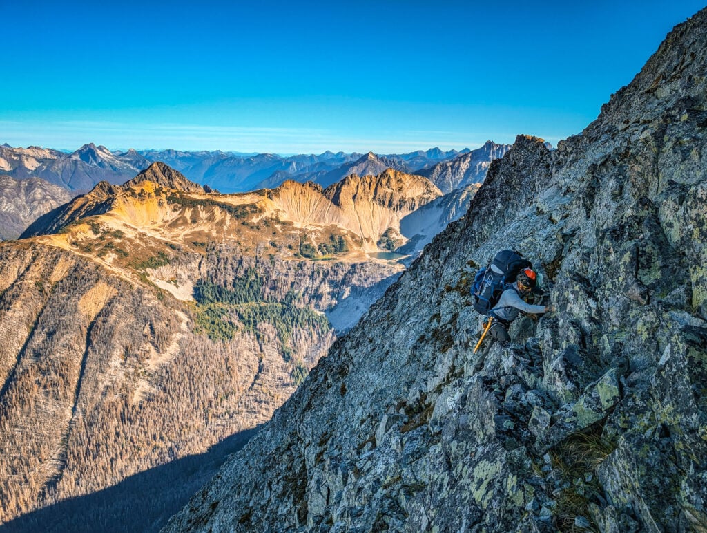 A climber ascends a rock summit in the remote alpine wilderness of the North Cascades during American Alpine Institute Alpine Mountaineering and Technical Leadership Part 4 (AMTL4)