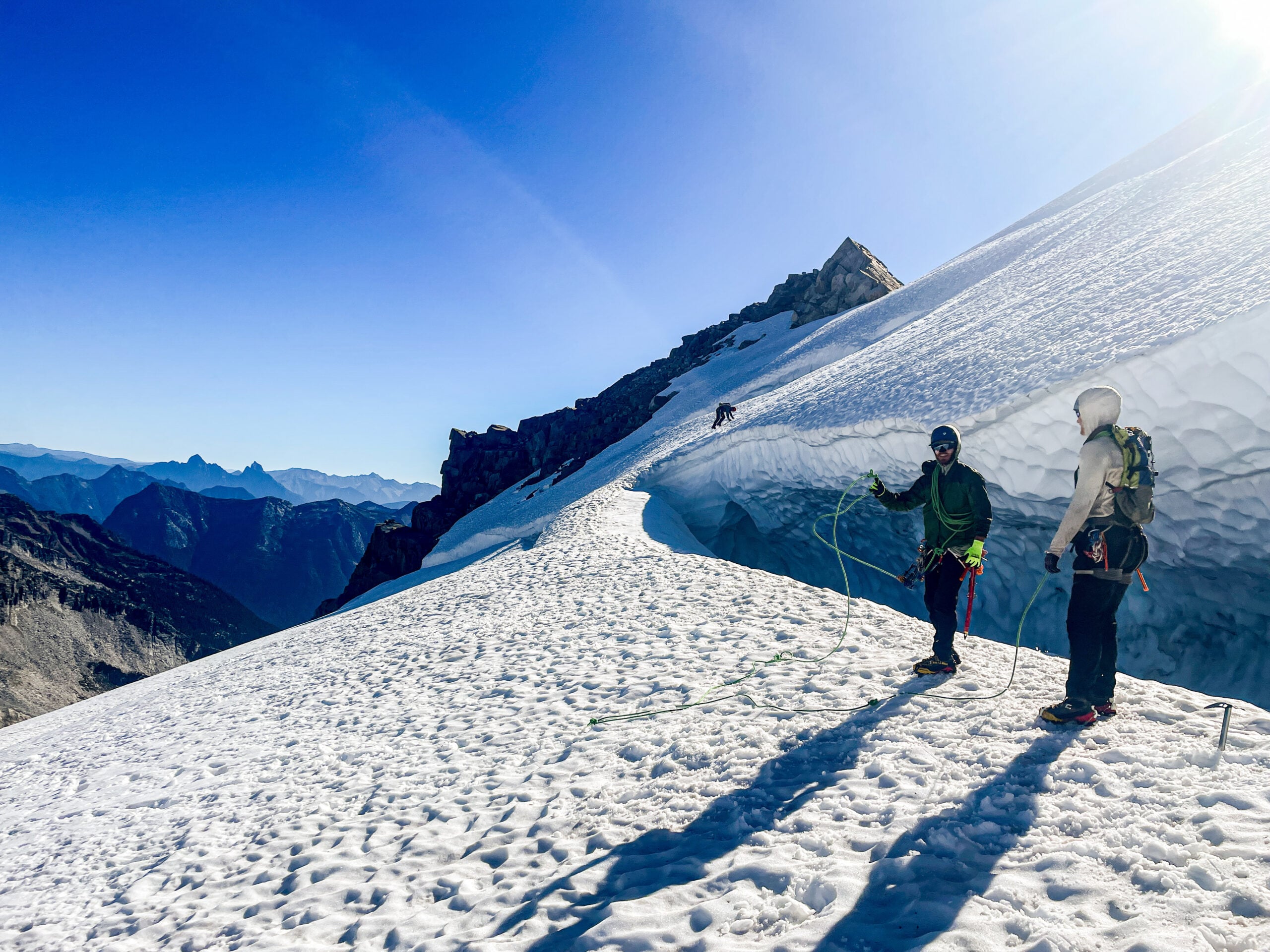 A team of climbers navigate a large bergschrund in the remote alpine wilderness of the North Cascades during American Alpine Institute Alpine Mountaineering and Technical Leadership Part 4 (AMTL4)