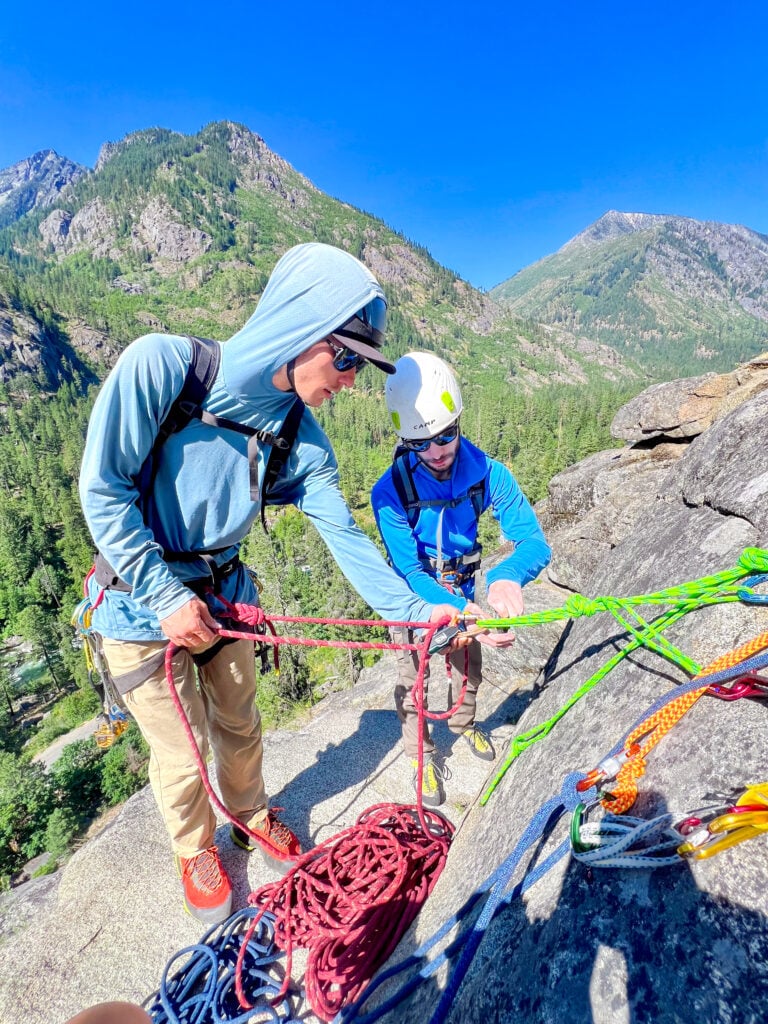 Rock climbing students at the belay anchor in Leavenworth, WA on an American Alpine Institute Rock climbing course