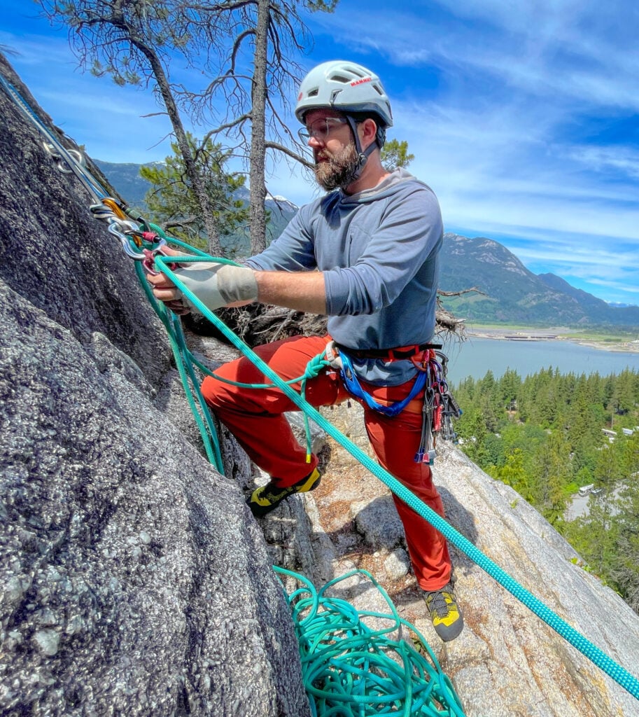 A climber manages the ropes at the anchor of pitch 2 of Concord Crack in Squamish, BC