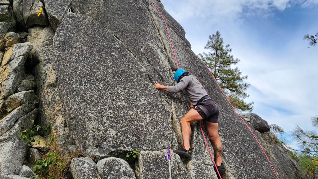 A climber gets on route during an American Alpine Institute rock climbing course