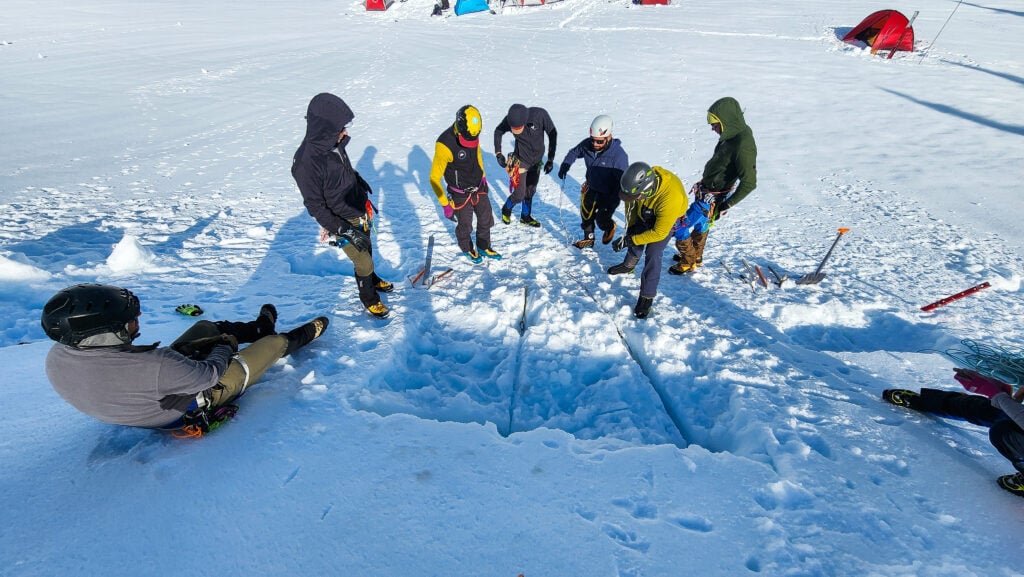 Students learn about snow anchors for rescue on an American Alpine Institute mountain rescue course