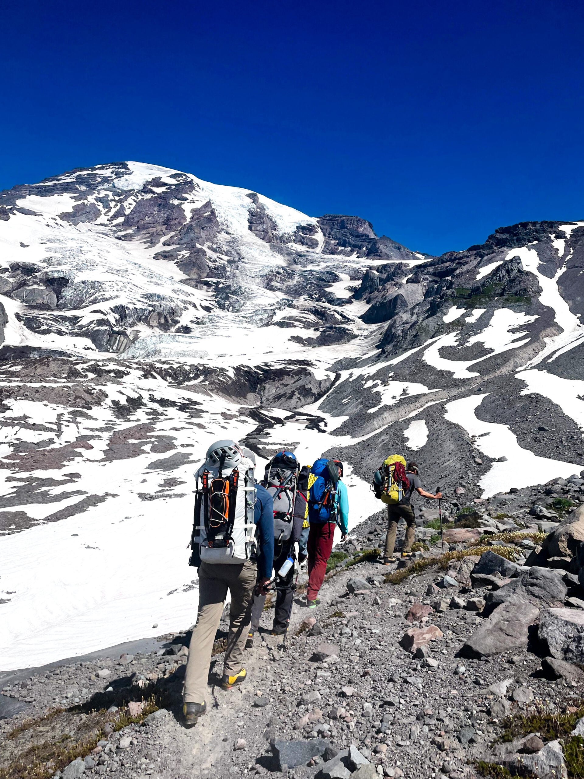 Mt. Rainier's summit looms in the sky as climbers make their way up the Kautz route on an American Alpine Institute mountaineering program