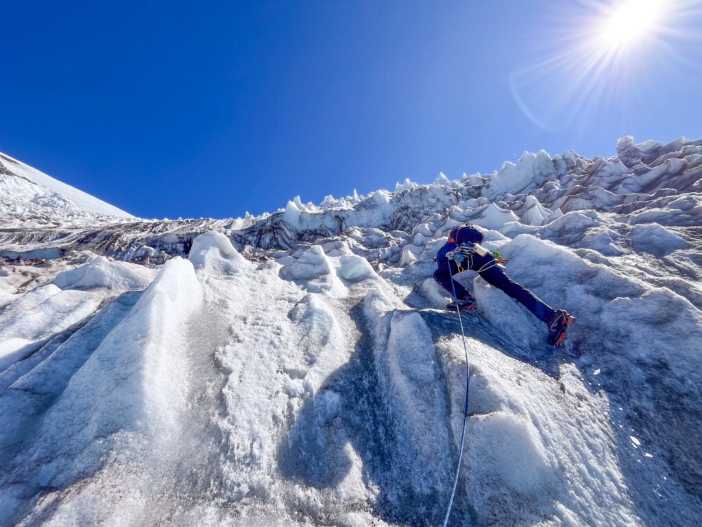 A climber navigates up an alpine ice slope on the Mt. Rainier Kautz glacier route on an American Alpine Institute mountaineering course