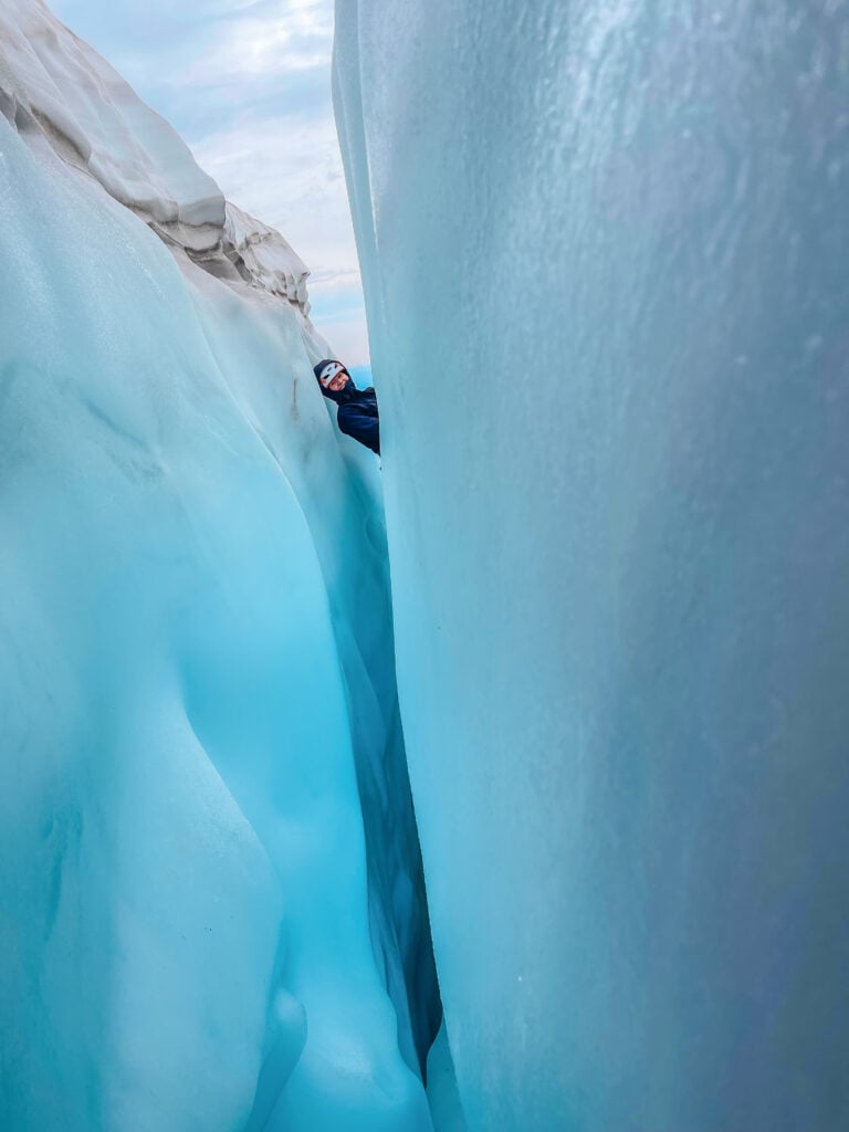 A climbing student peeks out from the blue ice of a crevasse on Mt. Baker during an American Alpine Institute mountaineering program