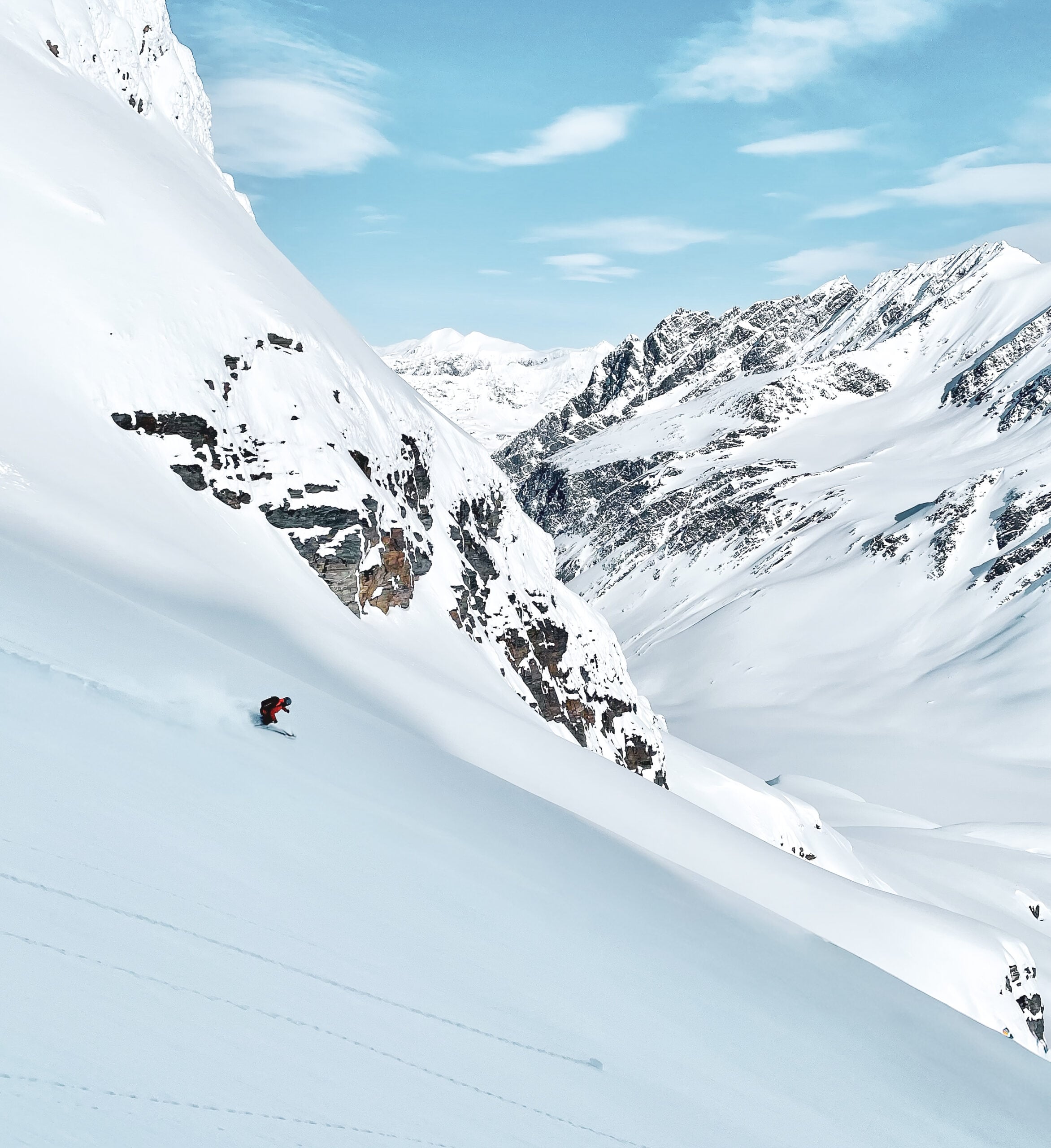 A skier descends a steep slope in the remote backcountry mountain on an American Alpine Institute ski program.