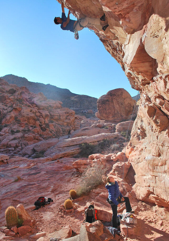 A rock climber belaying their partner in Red Rocks, NV during an American Alpine Institute rock climbing course