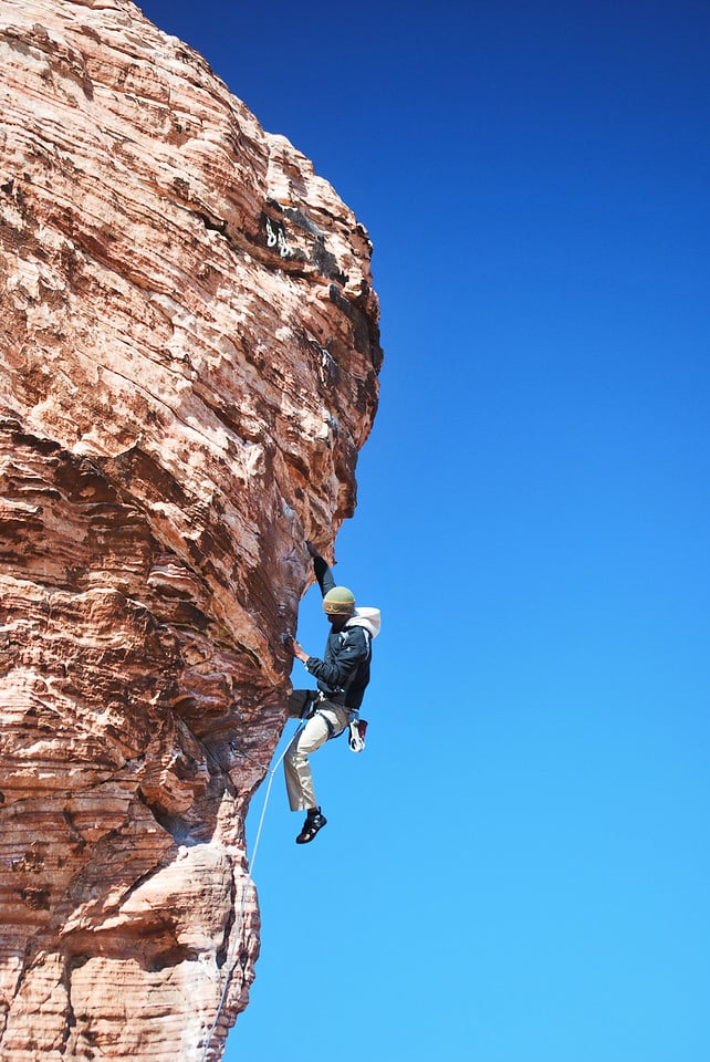 A rock climber reaches for the next hold in Red Rocks, NV on an American Alpine Institute rock climbing program