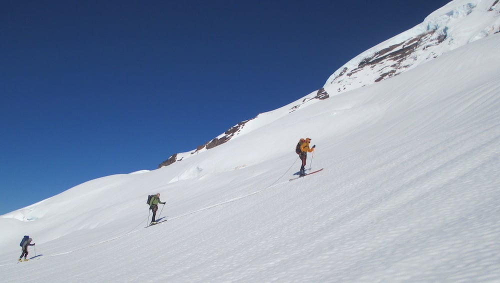roped-skiers-traversing-a-steep-glacier